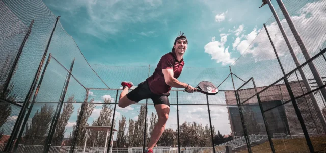 Joueur de padel frappant la balle sur un court extérieur