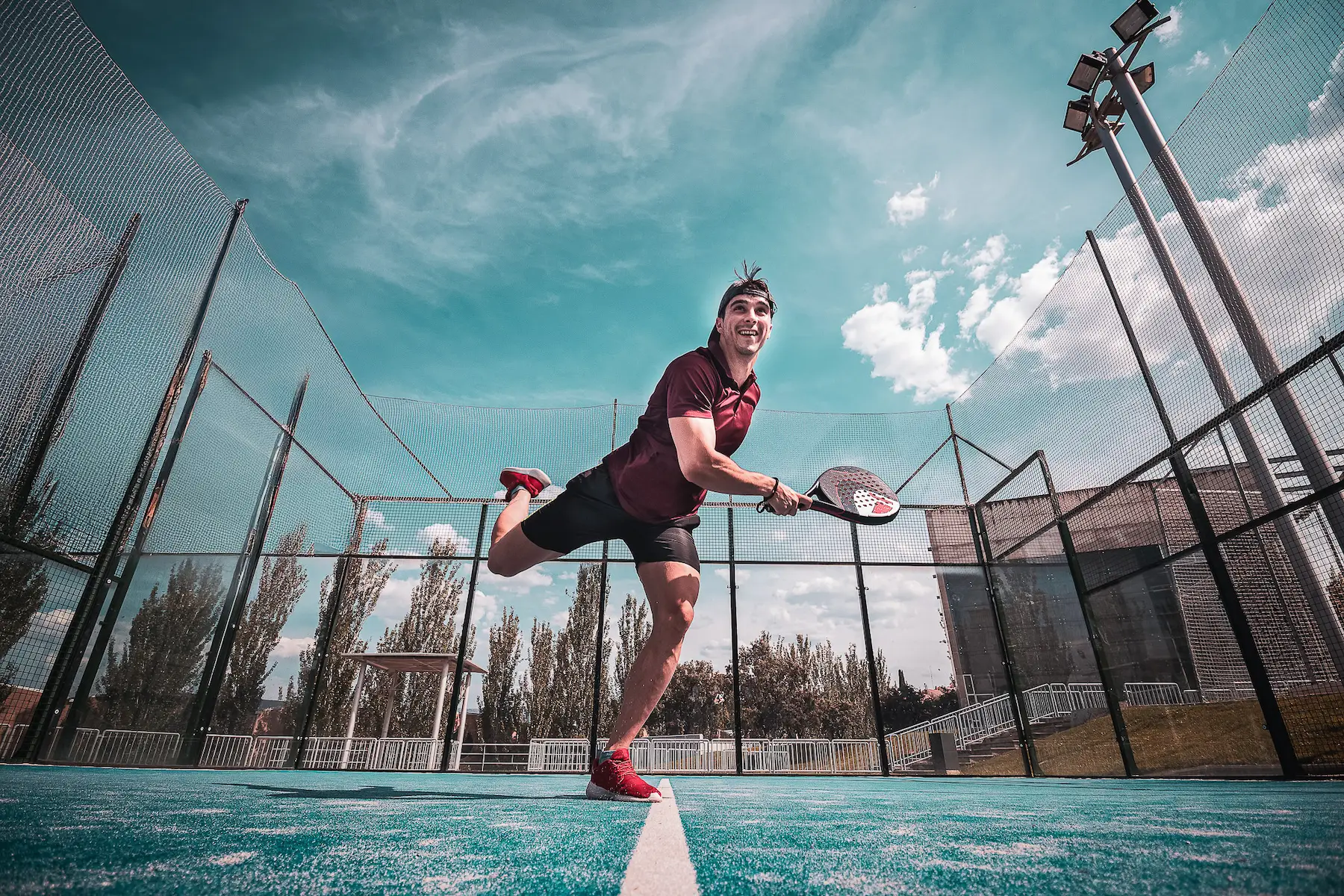 Joueur de padel frappant la balle sur un court extérieur